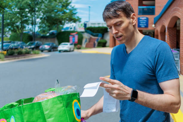 Close-up of mid adult white man checking receipt upon leaving supermarket
